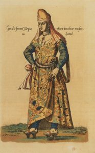 A Turkish woman in a traditional dress as a noblewoman with a head piece and clog shoes.