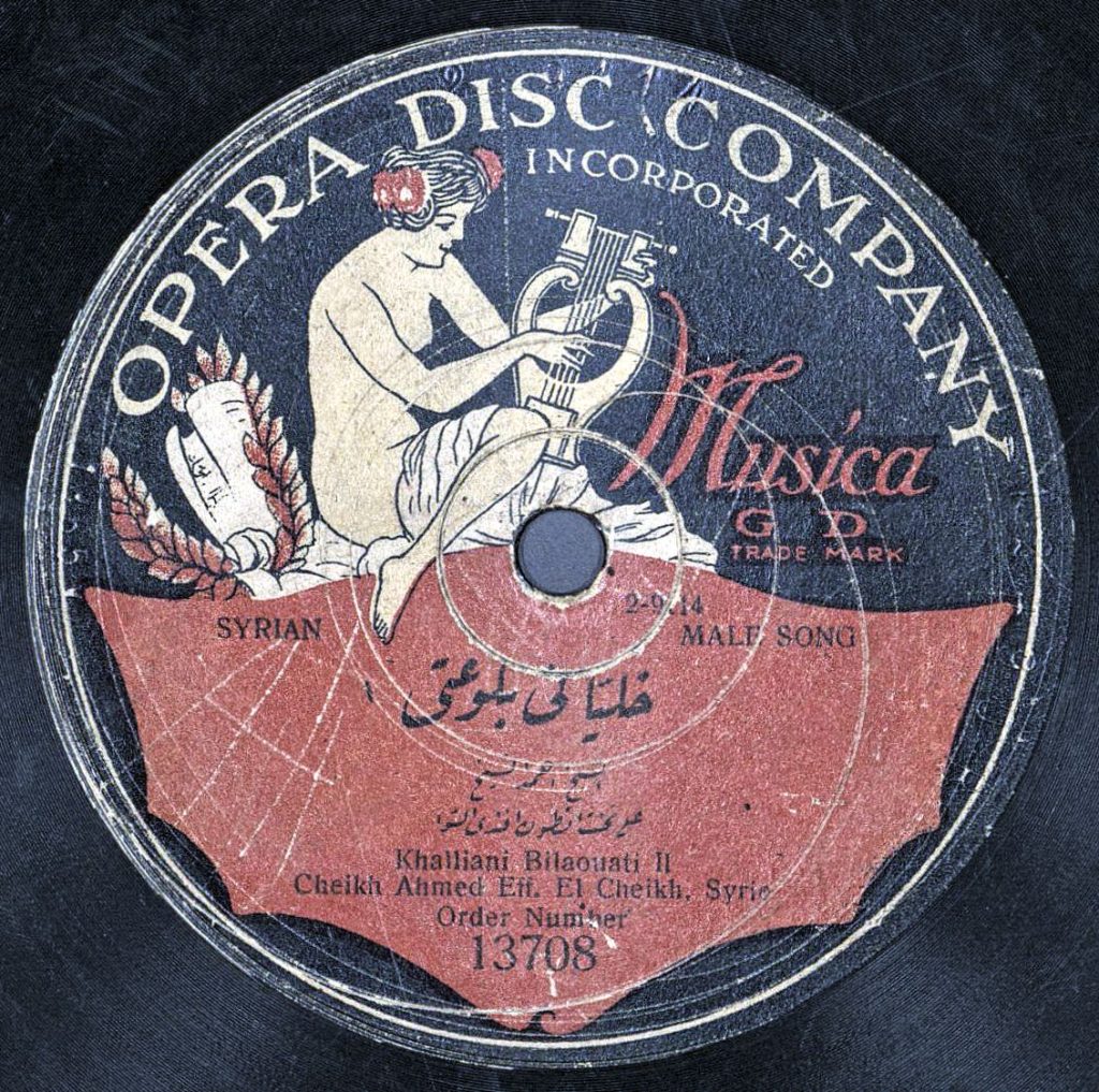 A record label with a drawing of a seated, mostly nude woman playing a lyre. The label reads "Opera Disc Company. Syrian Male Song."