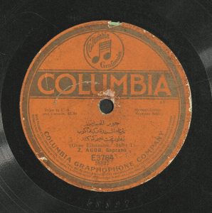 A sound disc with an orange label featuring the Columbia Graphophone Company logo and text in Arabic and English.