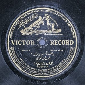 A sound disc with black label and gold letters and logo containing a phonograph and dog listening.