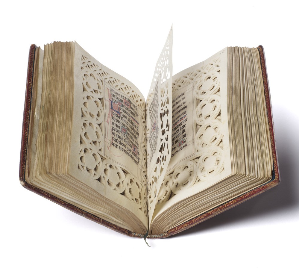 A manuscript book of hours with repeating patterns cut into its blank margins