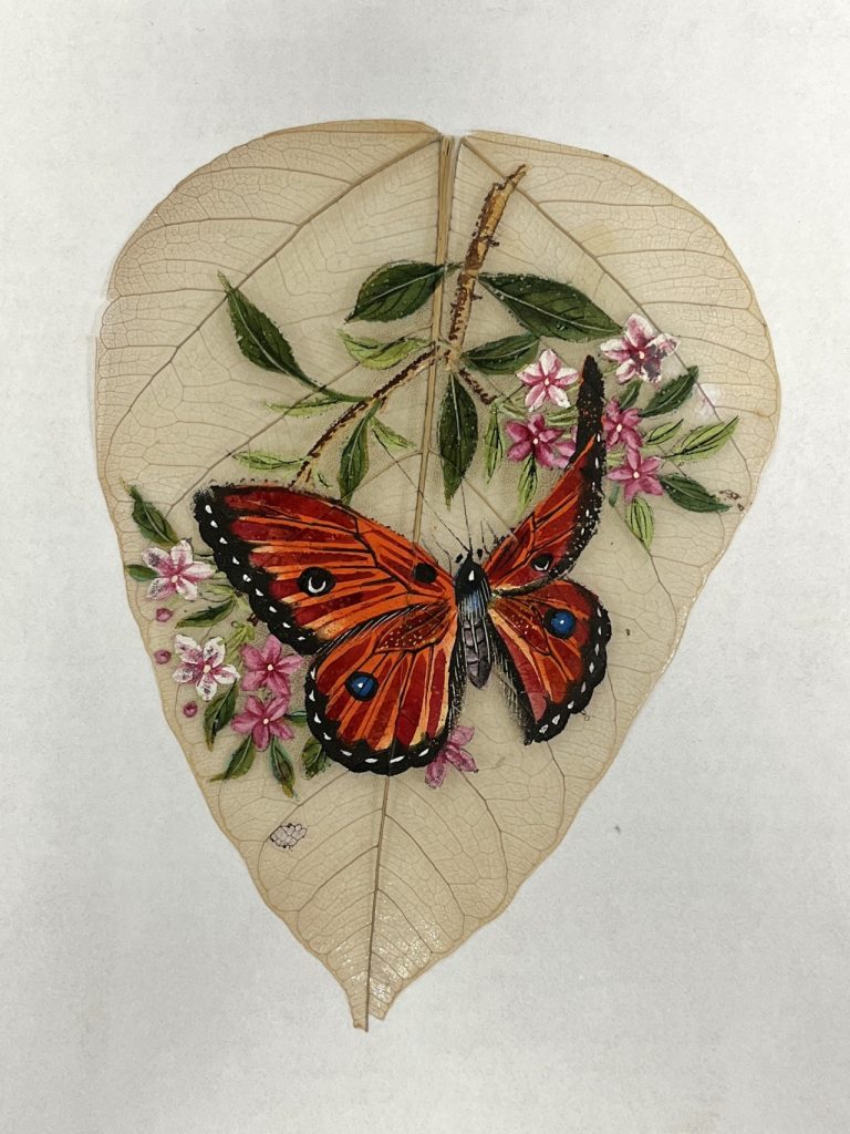 Leaf painting depicting flowers and a butterfly